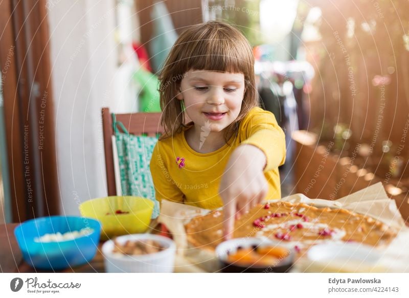 Little girl decorating mazurek (Polish Easter cake) table decoration hand food kitchen cooking family home eating meal healthy preparing baking colorful