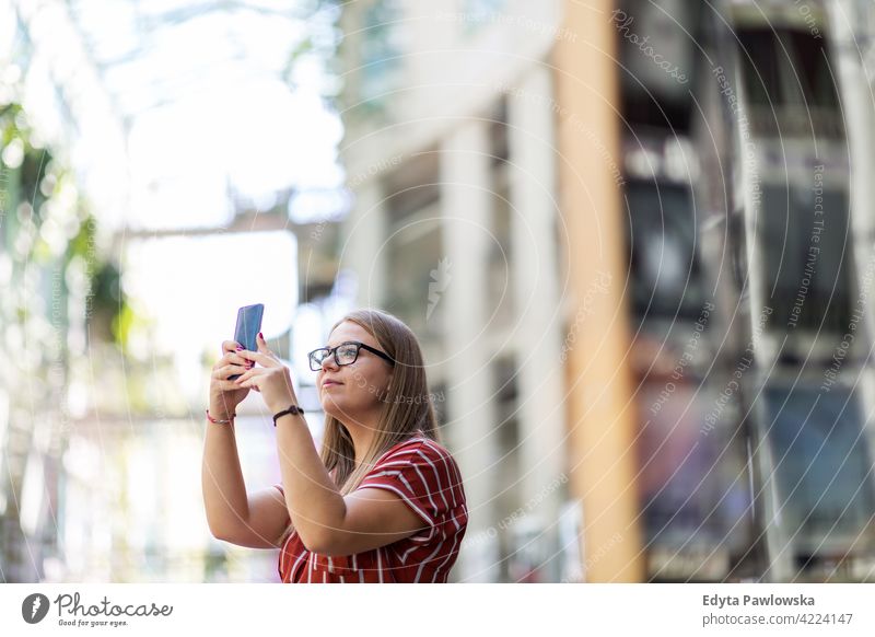 Young woman taking photo with her smart phone body positive Overweight Plus Size Model urban city active people young adult casual attractive female happy