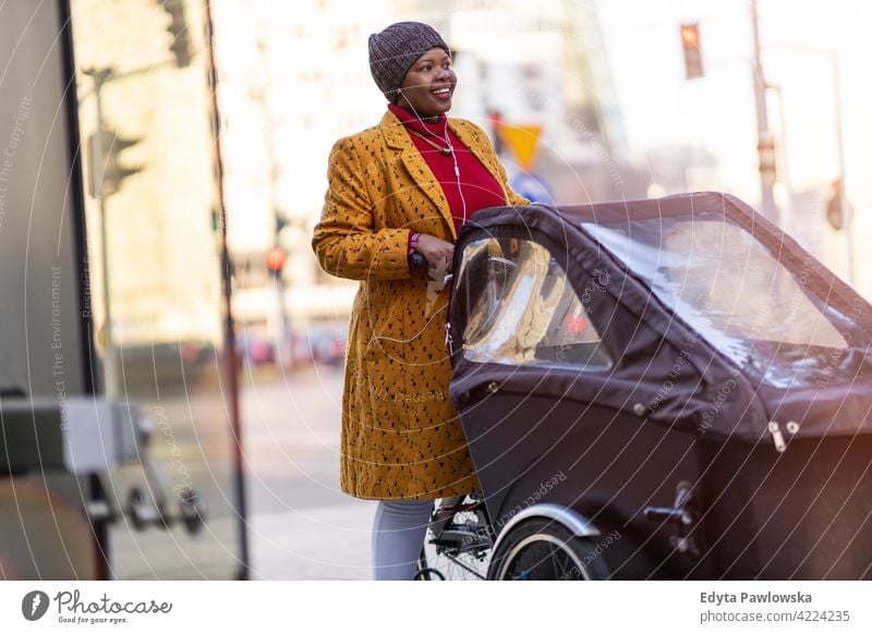 Woman using cargo bike in urban area outdoors day positivity confident carefree people woman young adult casual beautiful attractive female one person smiling