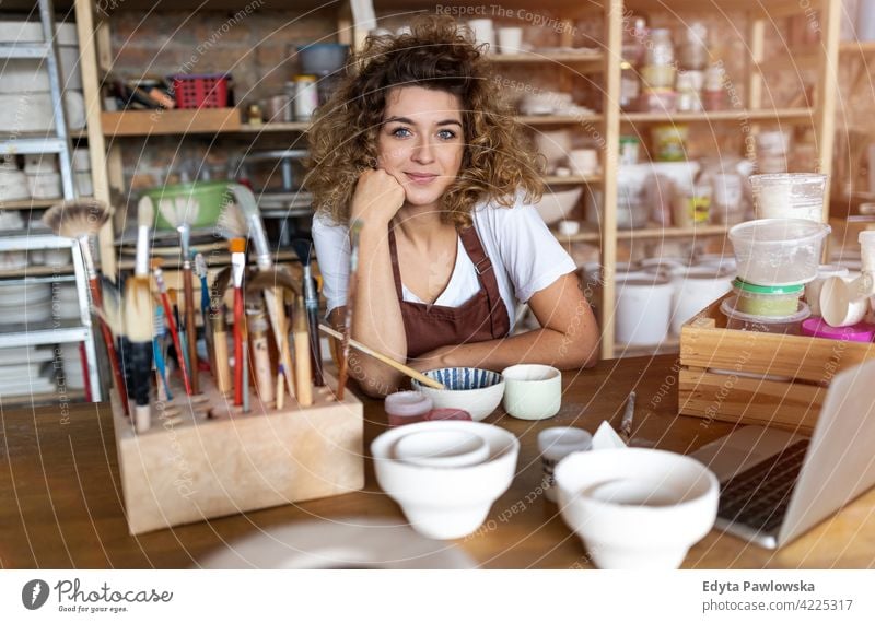 Portrait of woman pottery artist in art studio ceramics work working people young adult casual attractive female happy Caucasian enjoying one person beautiful