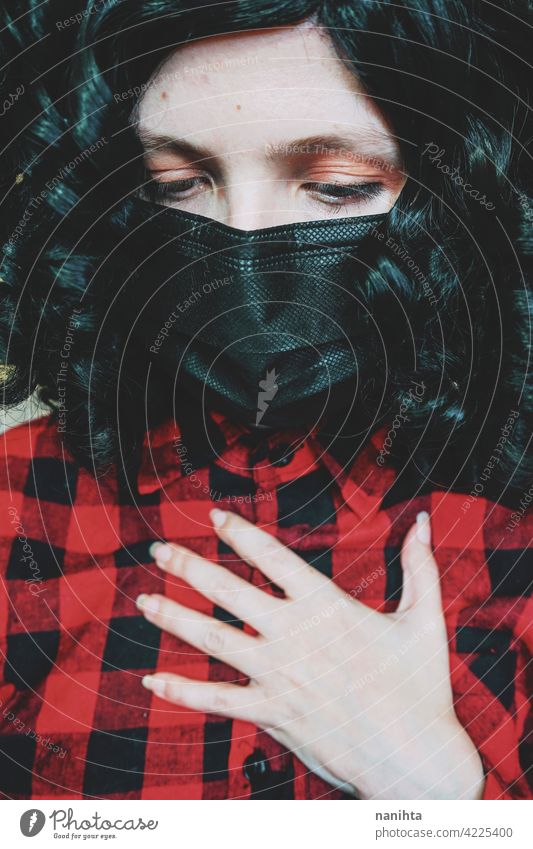 Young woman wearing a black face mask covid coronavirus influenza plaid hirt close up look green eyes white caucasian health health care medical curly