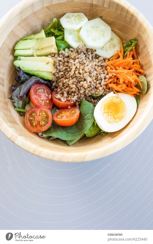 Brown rice salad with carrot, egg, cucumber, avocado, tomato and lamb's lettuce above antioxidant asian background bowl brown buddha bowl copy space cuisine