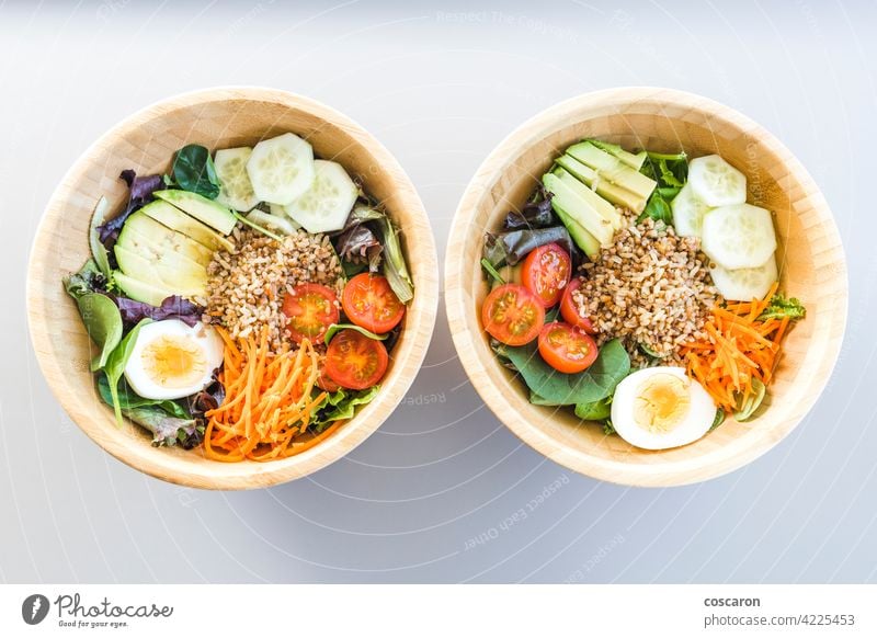 Brown rice salad with carrot, egg, cucumber, avocado, tomato and lamb's lettuce above antioxidant asian background bowl brown buddha bowl copy space cuisine