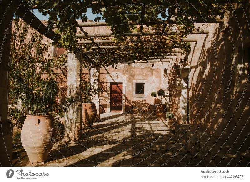 Old building yard decorated with lush climbing plants patio greenery historic medieval architecture heritage arkadi monastery structure construction exterior