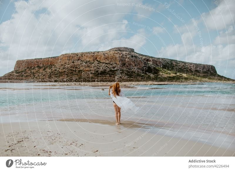 Attractive woman in swimwear standing on sandy seashore chill balos beach swimsuit rock resort paradise picturesque suntan rest bikini crete slim sunbath nature