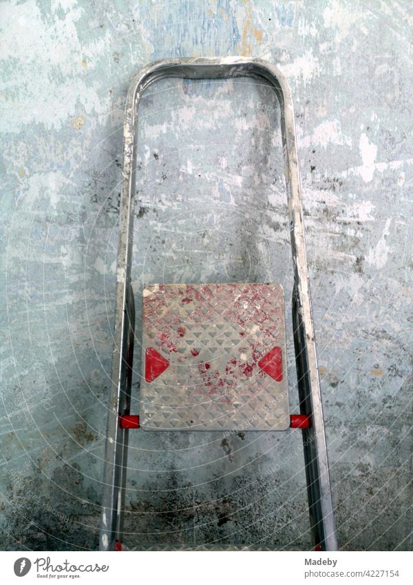 Aluminium folding ladder with paint residues in front of a plastered wall during the renovation of an old farmhouse in Rudersau near Rottenbuch in the district of Weilheim-Schongau in Upper Bavaria