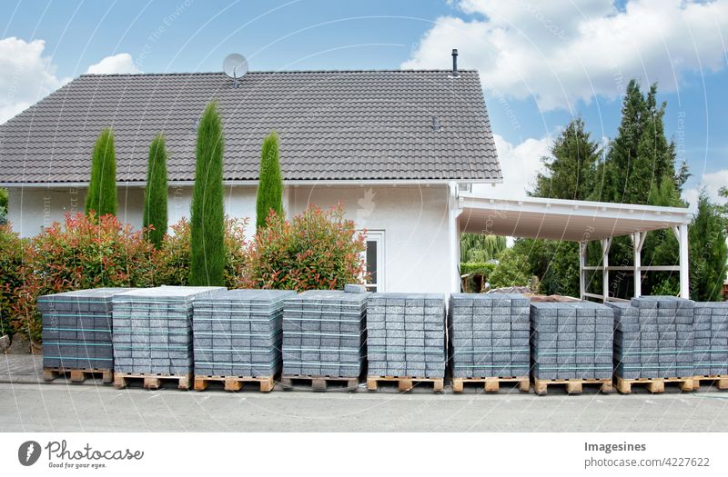 Construction in sight. Paving stones pallets delivered in front of a residential building for laying ready a driveway Building House (Residential Structure)