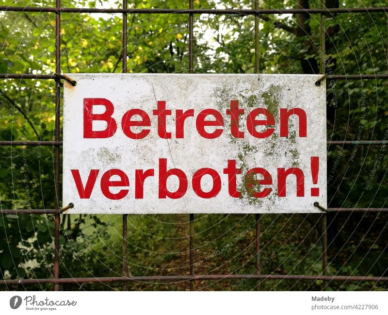 No trespassing sign on the rusty wire mesh of a yard gate in Oerlinghausen near Bielefeld on the Hermannsweg in the Teutoburg Forest in East Westphalia-Lippe