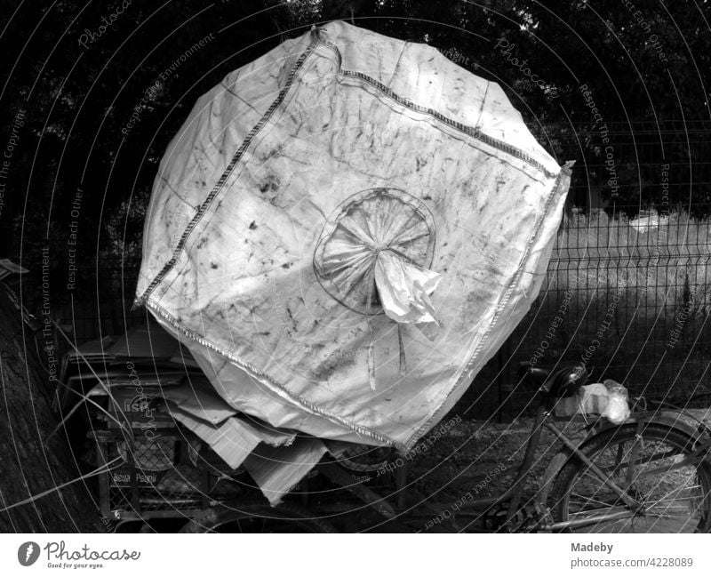 Oversized garbage bag on the old bicycle of a poor garbage collector in Adapazari, Sakarya province, Turkey, photographed in neo-realistic black and white