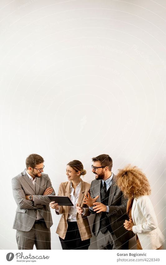 Multiethnic business people using digital tablet while standing by the wall in the office adult african american black businessman businesswoman caucasian