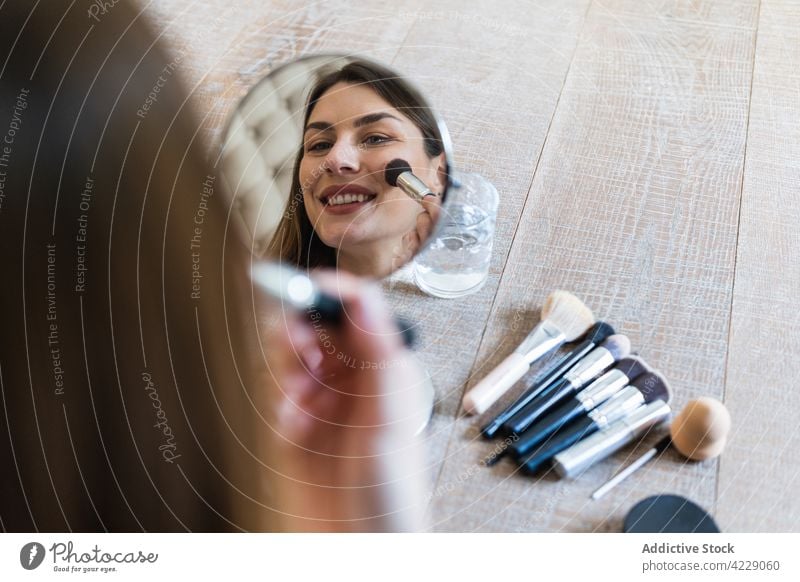 Happy woman applying powder and recording video on camera makeup blogger brush toothy smile visage cheerful influencer attractive happy cosmetic brunette