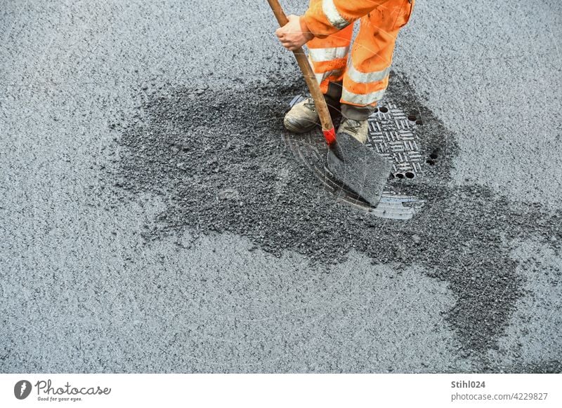 Road construction worker with orange work clothes and shovel roadman Shovel Orange Pants reflective labour Manhole cover asphalt work Asphalt Redevelop repair