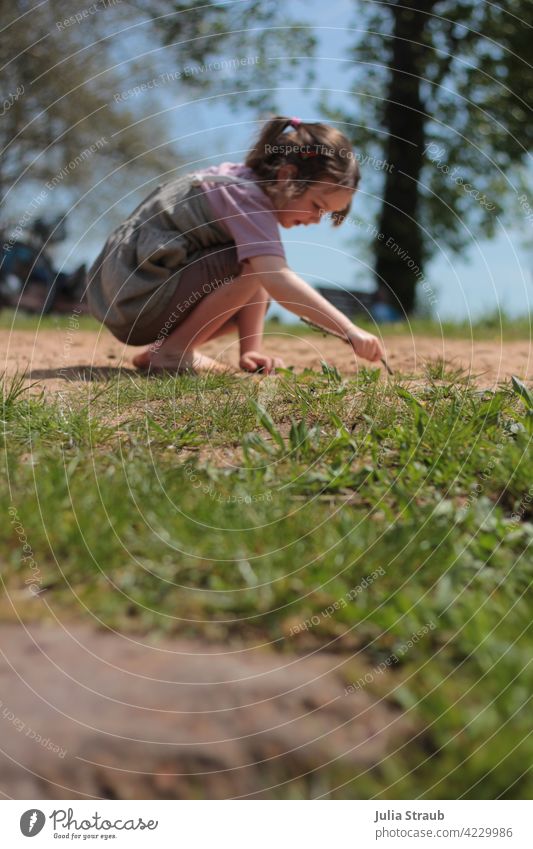 Girl drawing in the sand Playing be out Sand Meadow Grass Barefoot Dress T-shirt Braids Stick Write Draw Painting (action, artwork) Interpret Summer Spring Sun