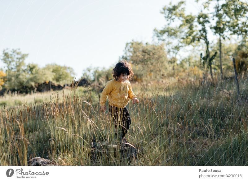 Child playing outdoors 1 - 3 years Girl Caucasian Spring Yellow Nature Field Happy childhood Cute Exterior shot Infancy Human being Day Colour photo Happiness