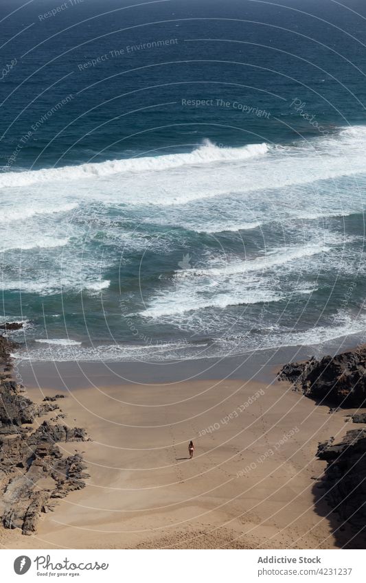 Unrecognizable tourist on shore against stormy sea traveler admire ocean mount nature highland beach wanderlust woman mountain landscape foam water rough trip