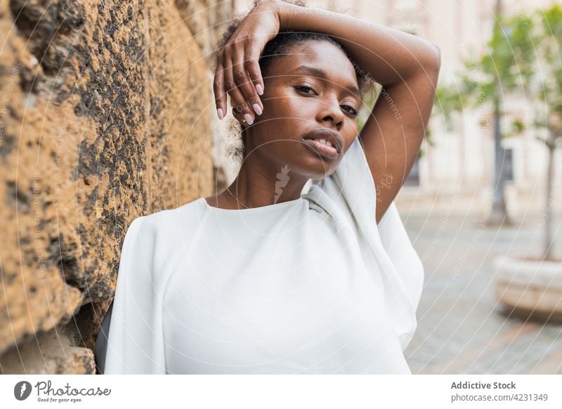 Black woman standing against historic buildings on clear day street city cheerful urban architecture spring facade tourist coat style lifestyle joy casual young