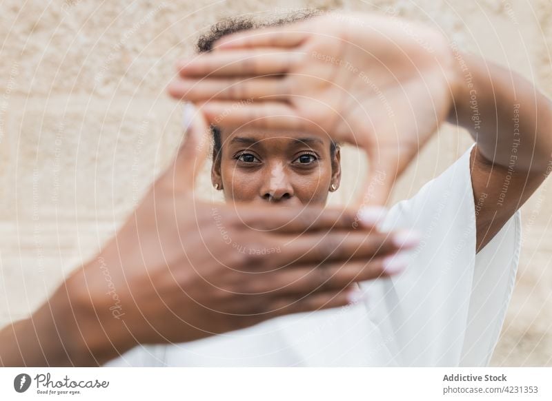 Joyful black woman showing showing on camera framing sign heart gesture happy love carefree frame like valentine romantic optimist cheerful glad expressive