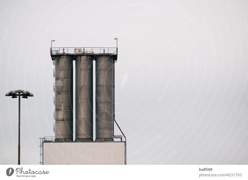 three silos in the harbour with spiral staircase and street lighting Silo Harbour Depot Logistics Minimalistic Industrial plant Storage Architecture Warehouse