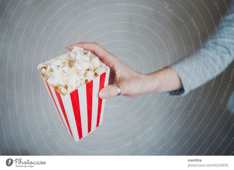 Woman holding a container full of pop corn cinema film vintage retro classic classy red white temptation snack woman enjoy hand lifestyle people food delicious