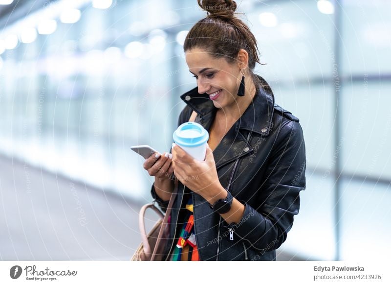 Young woman with smartphone in an urban city area street active people young adult casual attractive female happy Caucasian enjoying one person beautiful