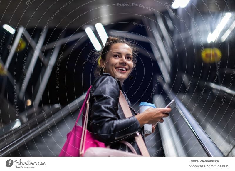 Woman with smartphone in downtown city street at night urban active people woman young adult casual attractive female happy Caucasian enjoying one person