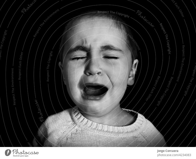 one year old girl with short hair cries uncontrollably in monochrome. Concept of anxiety, depression, childhood problems, emotions. cry sad baby young caucasian