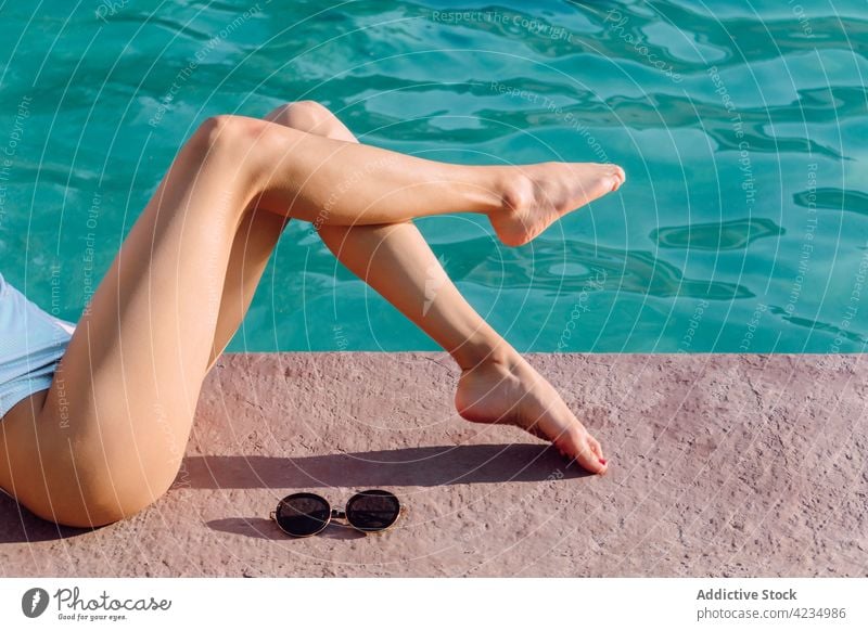 Crop girlfriends resting on poolside during summer vacation swimming resort trip travel ripple friendship barefoot women together best friend tourist pastime