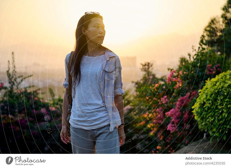 Asian female walking in garden woman model Chinese fashion one person enjoy relax sunset sunny nature grass lonely happy leisure sunlight beautiful long hair