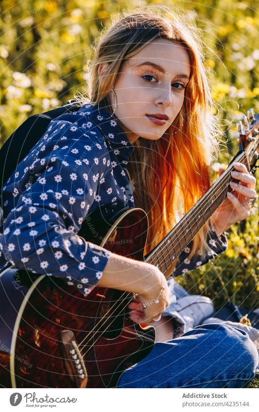 Young female playing guitar on nature woman summer countryside write hipster musician dreamer notebook summertime thoughtful lifestyle romantic meadow vacation