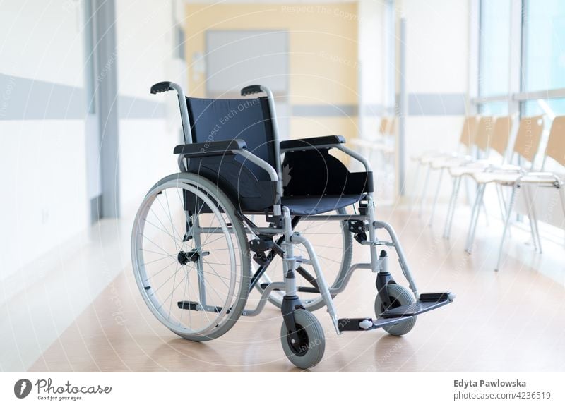 Empty wheelchair in hospital corridor empty no-one nobody no people absence wheel chair disability physical impairment Handicapped mobility support