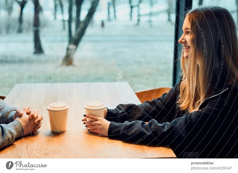 Friends having a chat, talking together, drinking coffee, sitting in a cafe. Young man and woman having a break, relaxing in cafe buy person restaurant