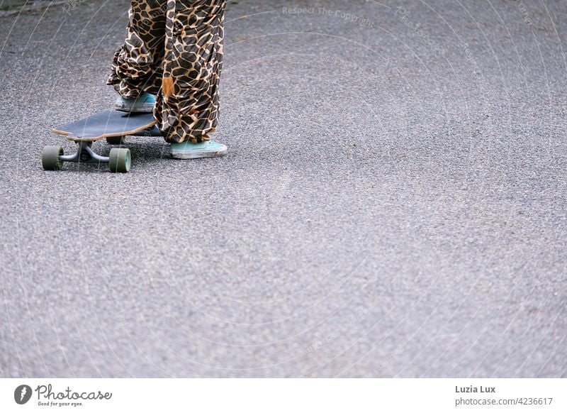 ready to push off: a girl in a carnival costume stands on an old skateboard (partial view) Skateboard Rebound Ready Costume Giraffe Whimsical wittily zeitgeist