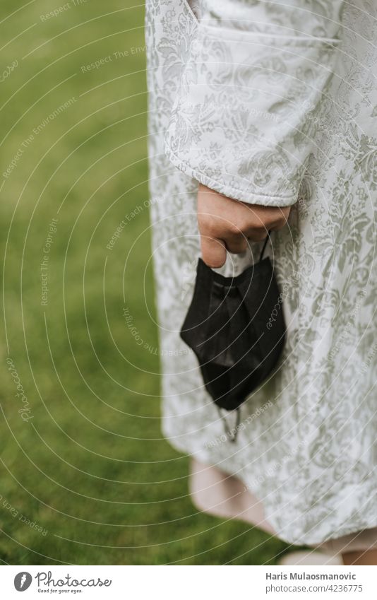 holding face mask in hand close up outdoors in nature 2019-ncov care closeup cloth corona virus coronavirus covid 19 covid-19 disease doctor dress epidemic