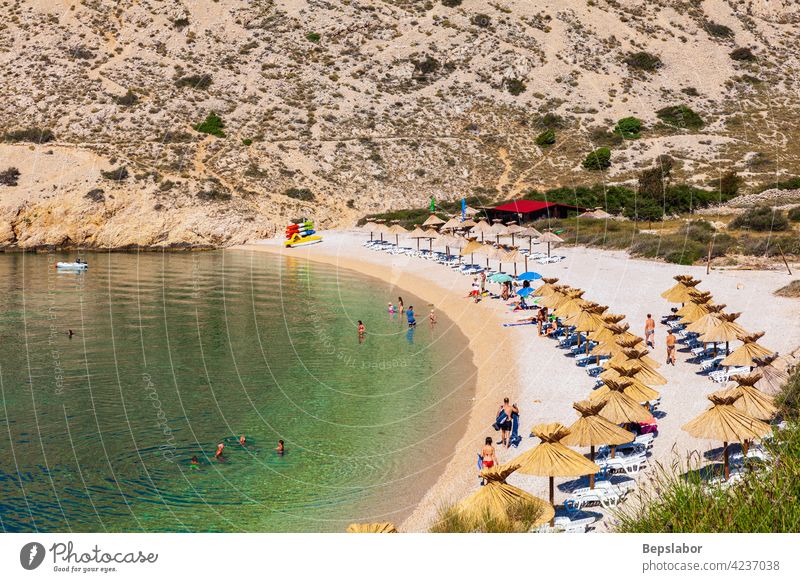 View of the beautiful Oprna beach in the adriatic bay of the Krk island oprna tourist straw umbrella wave croatia sea summer krk sand summertime resort blue