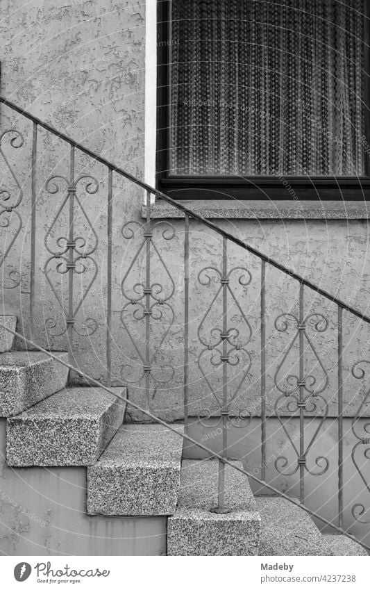 Bourgeois idyll with wrought iron banister and curtains behind the window of a residential house in Oerlinghausen near Bielefeld in the Teutoburg Forest in East Westphalia-Lippe, photographed in classic black and white