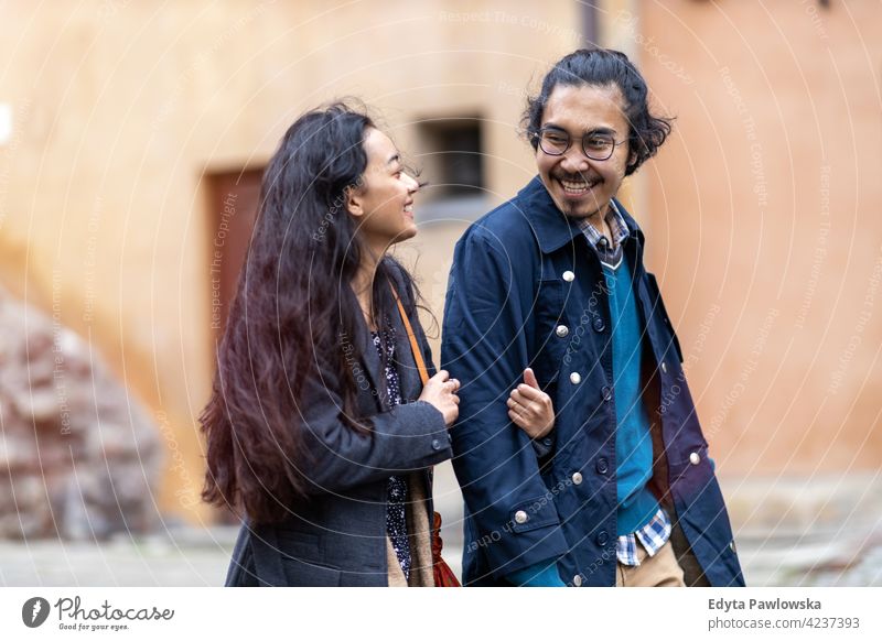 Happy young couple, walking through the old city, Warsaw, Poland warm clothing autumn fall urban Old Town people woman beautiful attractive girl male female