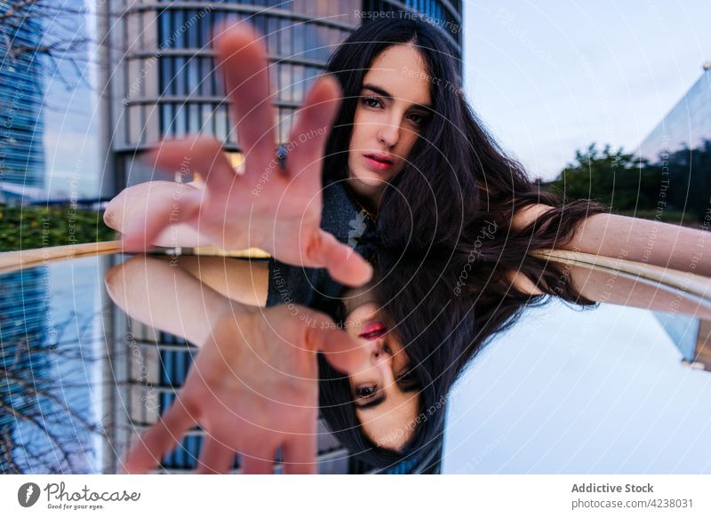 Woman lying on grass near skyscraper and reflecting in mirror woman reflection tower outstretch architecture emotionless urban facade style cool modern calm