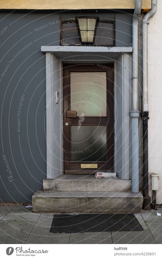 monotonous dreary house entrance with waste paper on the steps Entrance entrance area Mailbox Vacancy forsake sb./sth. dreariness Closed business expense Stairs