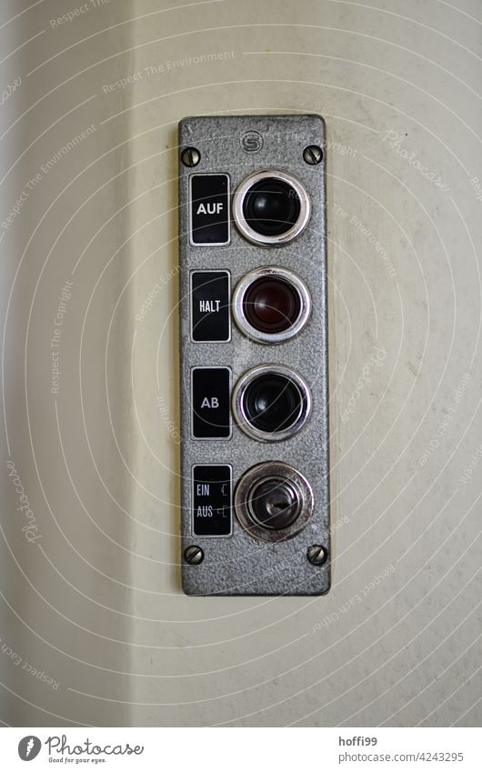 old switch plate / control panel of a freight elevator Switch Goods lift Upward Downward Hold as of one from button Switch panel Elevator Control panel Detail