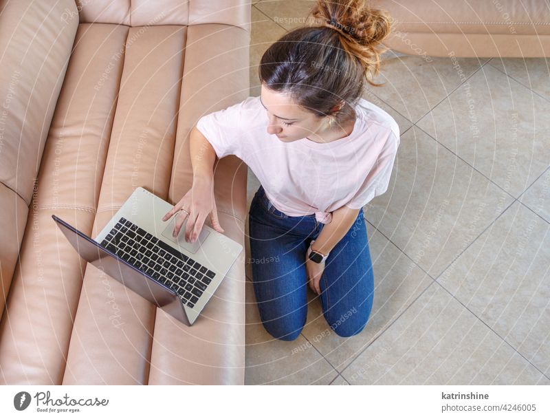 Young women using laptop while sitting on the floor at home wear mockup t-shirt learn student Lifestyle jeans glasses serious concentrated indoor sofa couch