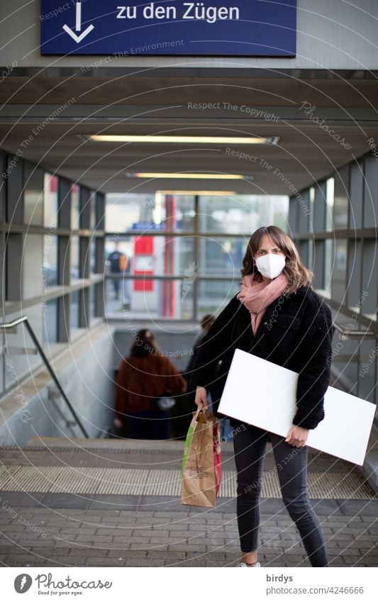 slim young woman with FFP2 mask and luggage at the station. Train traveler Corona virus Mask guard sb./sth. covid-19 corona PUBLIC TRANSPORT trains Arrow