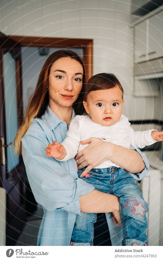 Serene mother holding baby at home love motherhood childcare embrace caress parent tender together bonding woman babyhood mom childhood cuddle affection