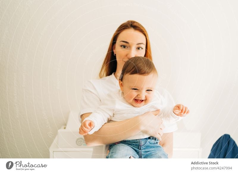 Serene mother holding baby at home love motherhood childcare embrace caress parent tender together bonding woman babyhood mom childhood cuddle affection