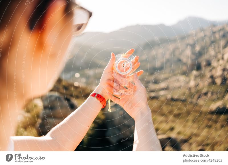 Unrecognizable female hiker holding compass in mountains woman traveler navigate orientate adventure vacation journey trip young sunglasses nature slope