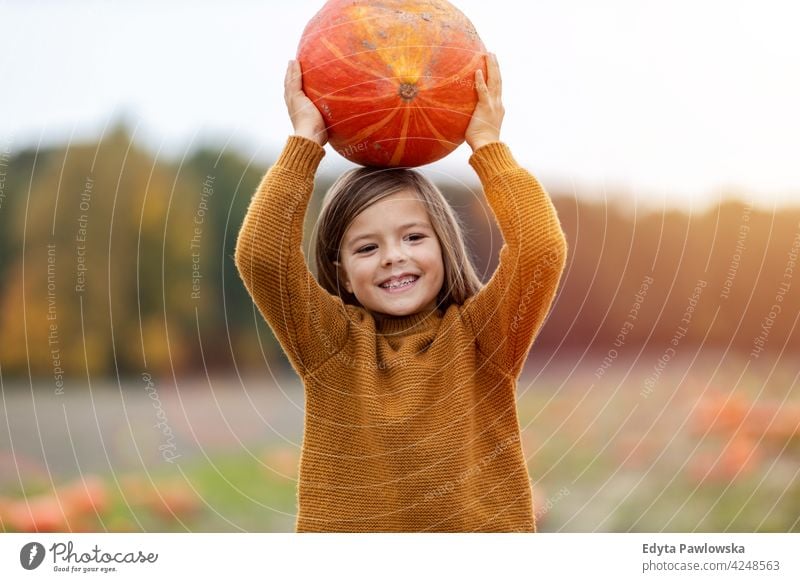 Cute little boy having fun in a pumpkin patch halloween nature field park autumn fall family kids children people happy smiling caucasian enjoying outdoors