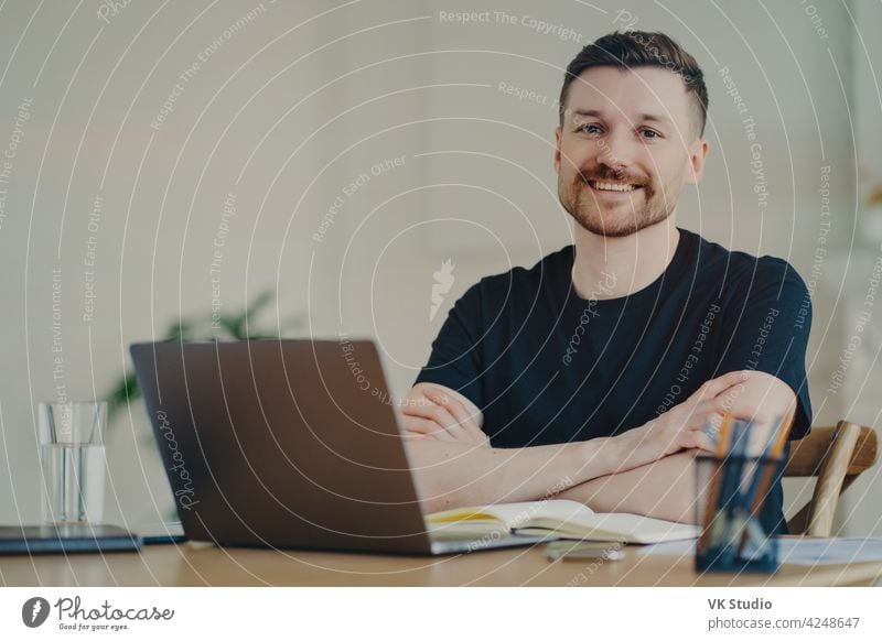 Portrait of happy businessman in casual wear sitting at his workplace in office or home freelancer smiling positive remote work work from home remotely employee