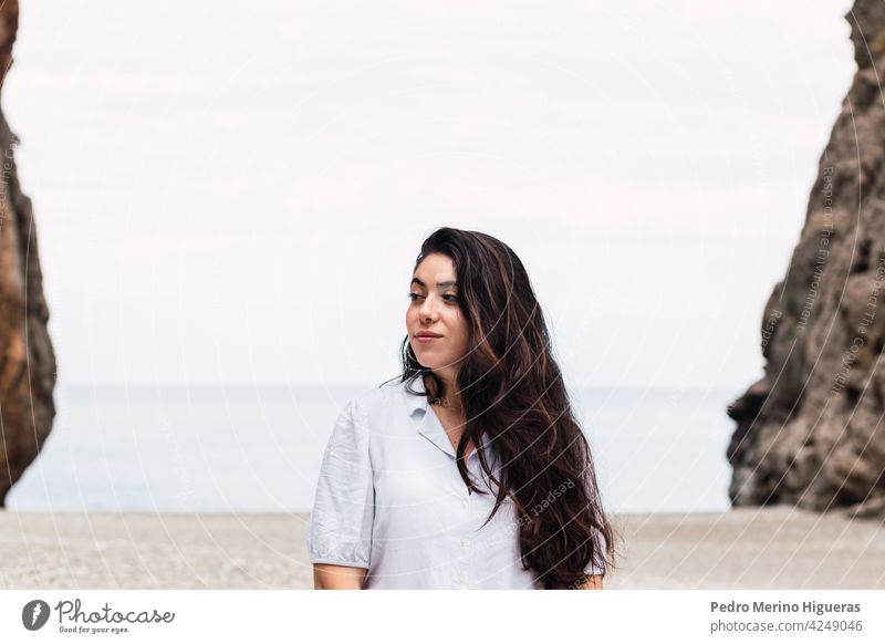 beautiful woman white dressed in a pebble beach girl nature background outdoor travel outdoors natural cliff sky caucasian vacation water view ocean hiking