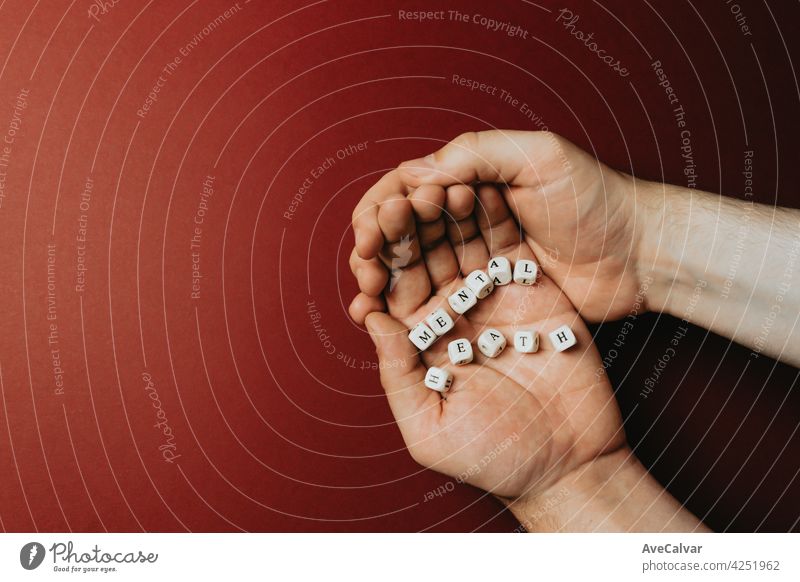 Hands holding one the words mental health over a dark red background, mental health concept with copy space Advice Help Patient Problem Psychological