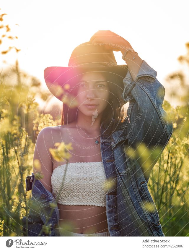 Woman in hat standing on verdant field woman joyful style blossom summer nature carefree sunny rapeseed feminine bloom serene emotional attractive beautiful