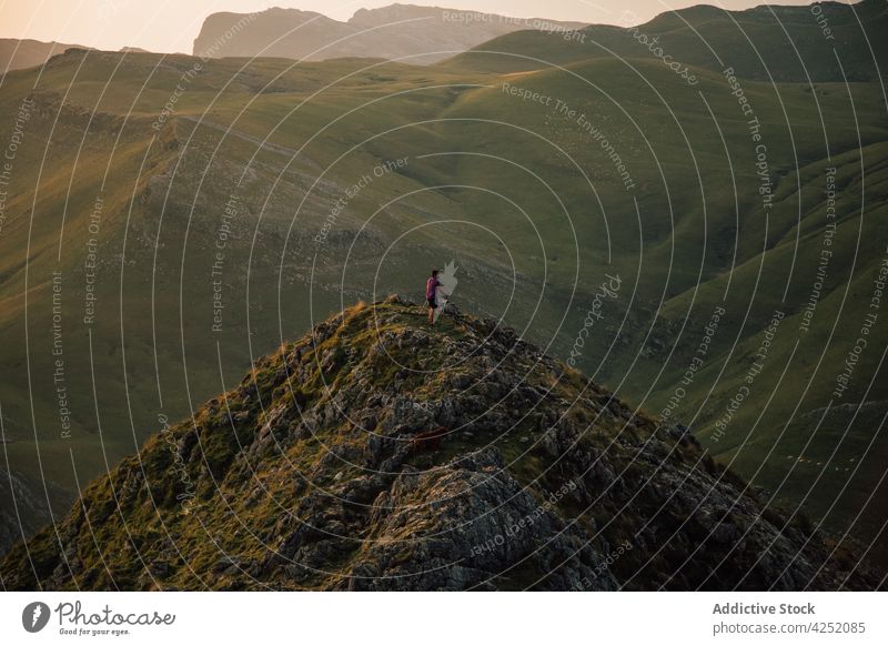 Person running on green cliff of mountain person freedom highland nature stone trekking landscape rock traveler hill scenic valley scenery slope tourism walk